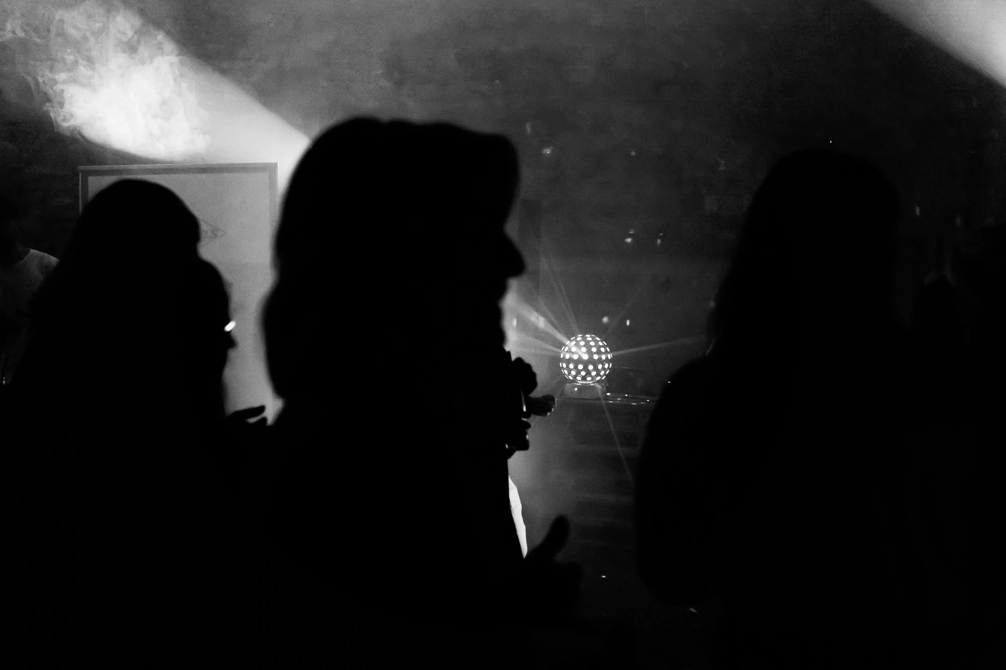 Silhouetten auf der Tanzfläche – Lichtball und Nebel